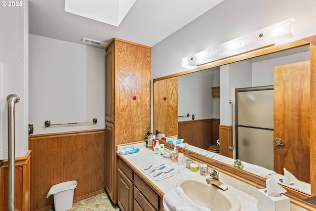 705 Prefontaine Dr, Coos Bay, OR 97420 - full bath featuring a skylight, a shower stall, vanity, a wainscoted wall, and wooden walls