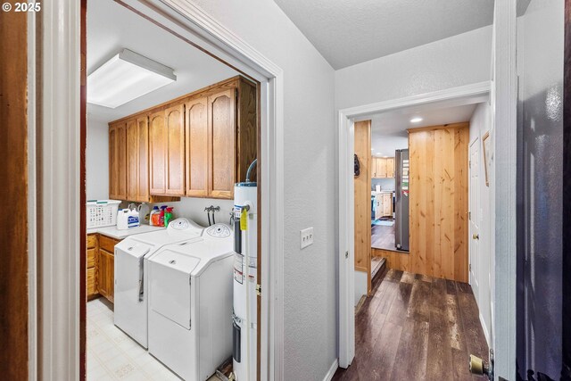 705 Prefontaine Dr, Coos Bay, OR 97420 - laundry room with cabinet space, water heater, light wood-type flooring, washing machine and clothes dryer, and a textured wall