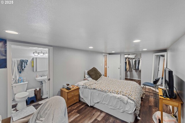 705 Prefontaine Dr, Coos Bay, OR 97420 - bedroom featuring dark wood-style flooring, a closet, recessed lighting, a sink, and ensuite bath