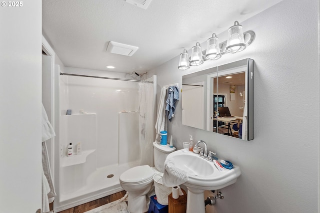 705 Prefontaine Dr, Coos Bay, OR 97420 - bathroom featuring a shower with curtain, toilet, wood finished floors, and a textured ceiling