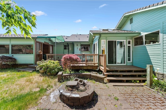 705 Prefontaine Dr, Coos Bay, OR 97420 - back of property featuring a deck, an outdoor fire pit, and a sunroom
