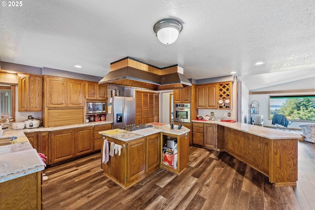 705 Prefontaine Dr, Coos Bay, OR 97420 - kitchen featuring appliances with stainless steel finishes, a textured ceiling, a peninsula, dark wood-type flooring, and brown cabinets