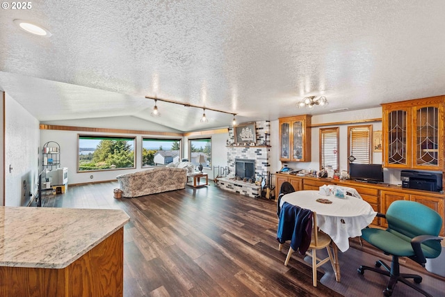 705 Prefontaine Dr, Coos Bay, OR 97420 - dining space featuring a textured ceiling, dark wood finished floors, a fireplace, and vaulted ceiling