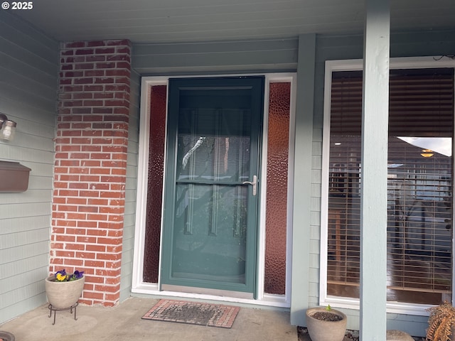 doorway to property with brick siding