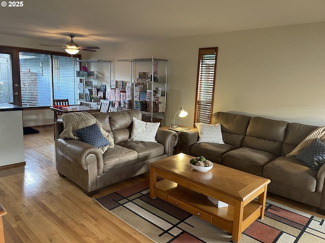 living area with a ceiling fan and wood finished floors