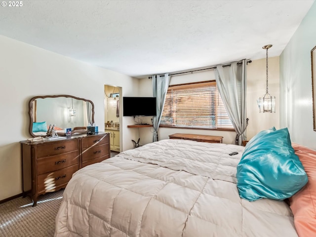 bedroom featuring ensuite bathroom, a chandelier, and carpet