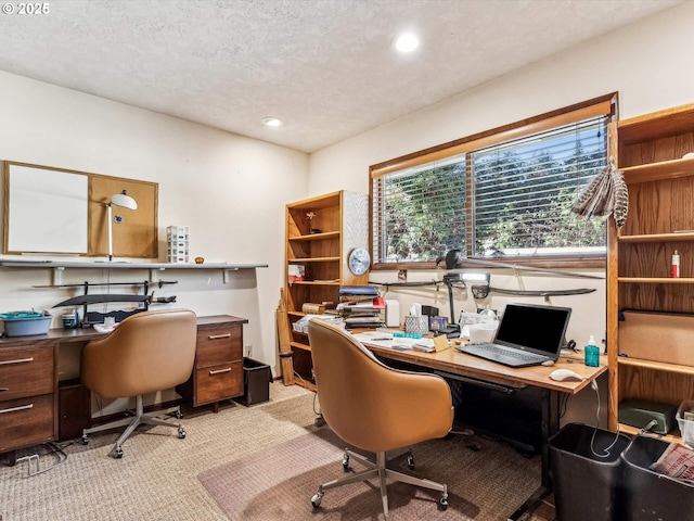 carpeted office featuring a textured ceiling