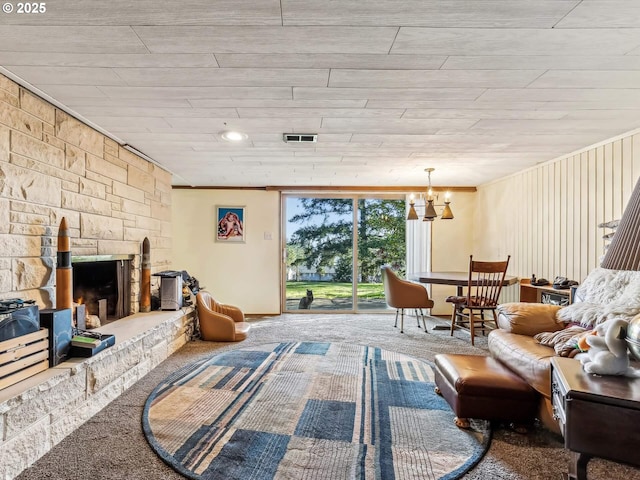 carpeted living room featuring a notable chandelier and a fireplace