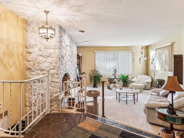 carpeted living room featuring an inviting chandelier and a stone fireplace