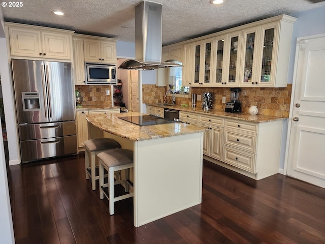 kitchen with dark wood-style floors, stainless steel appliances, glass insert cabinets, and island range hood