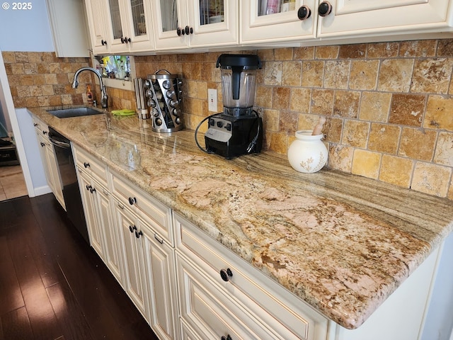 kitchen featuring a sink, light stone countertops, backsplash, and dishwasher