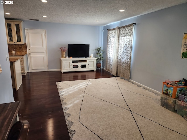 living area featuring recessed lighting, wood finished floors, baseboards, and a textured ceiling