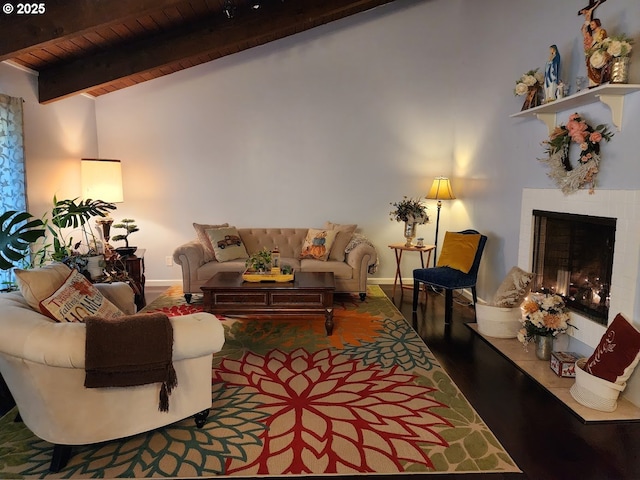 living room featuring baseboards, lofted ceiling with beams, a fireplace, wooden ceiling, and wood finished floors