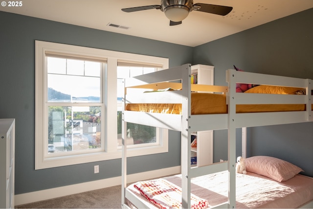 carpeted bedroom featuring multiple windows and baseboards