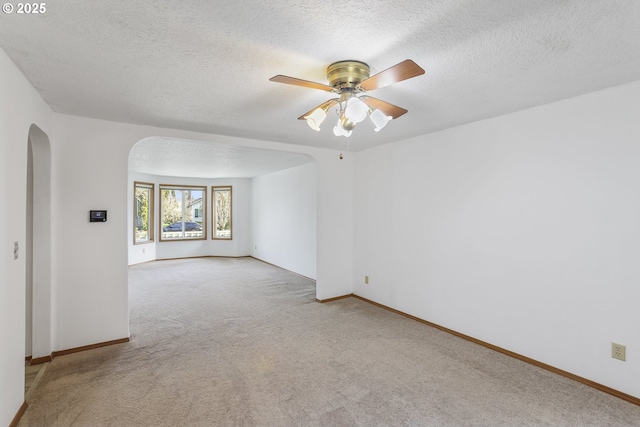 carpeted spare room featuring a textured ceiling and ceiling fan