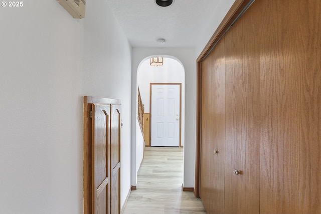 hallway featuring light hardwood / wood-style flooring and a textured ceiling