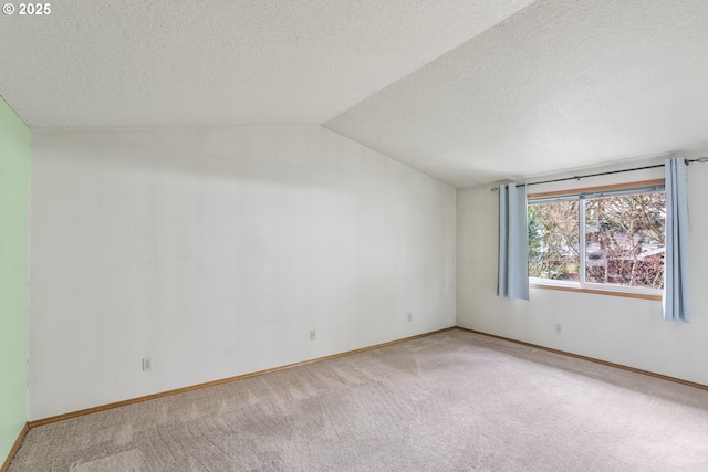 carpeted empty room featuring lofted ceiling and a textured ceiling