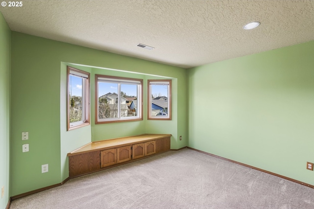 carpeted spare room with a textured ceiling