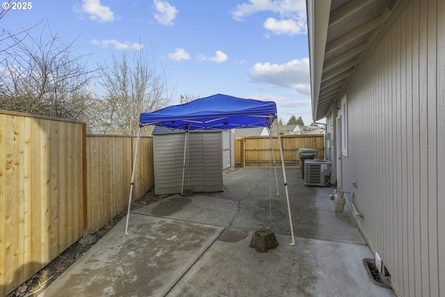 view of patio / terrace with a storage shed and central air condition unit