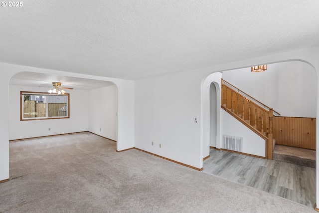 interior space featuring a textured ceiling, light colored carpet, and ceiling fan