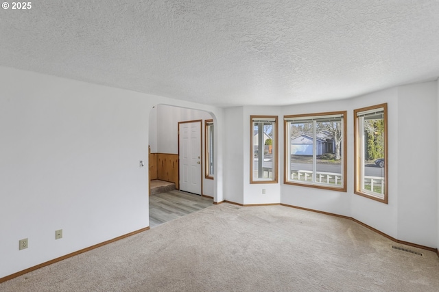 carpeted spare room featuring a textured ceiling