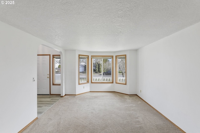 carpeted spare room featuring a textured ceiling