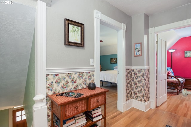 hallway featuring a textured wall and light wood-style flooring