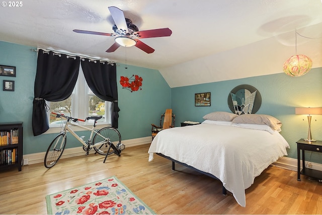 bedroom with lofted ceiling, baseboards, and wood finished floors