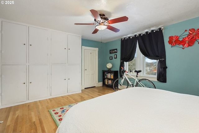 bedroom featuring a ceiling fan, light wood-type flooring, and a closet