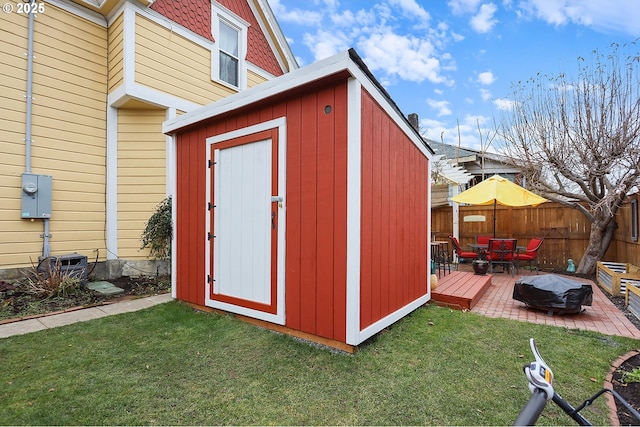 view of shed featuring fence and a fire pit