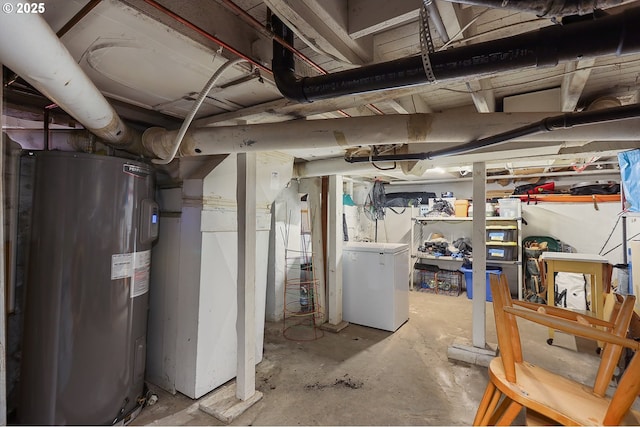 unfinished basement with water heater and refrigerator