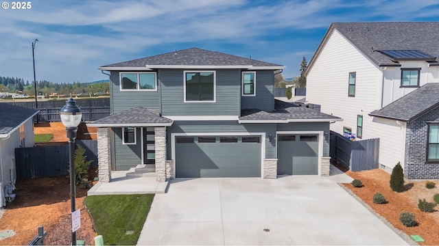 4308 N 12th Way, Ridgefield, WA 98642 - prairie-style house featuring a garage, fence, stone siding, and concrete driveway