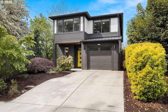 modern home with a standing seam roof, concrete driveway, metal roof, and a garage