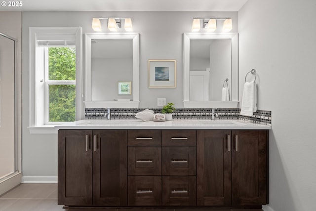 bathroom featuring double vanity, tile patterned floors, tasteful backsplash, a sink, and a shower stall