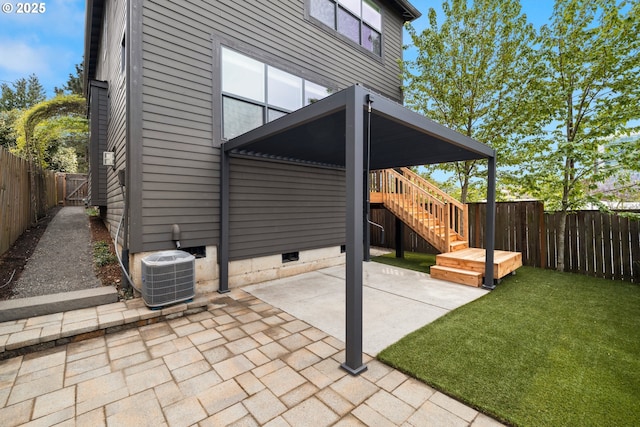view of patio / terrace with a fenced backyard, central AC, and stairway