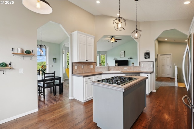 16117 SE Goosehollow Dr, Damascus, OR 97089 - kitchen with black gas stovetop, a ceiling fan, arched walkways, a center island, and white cabinetry