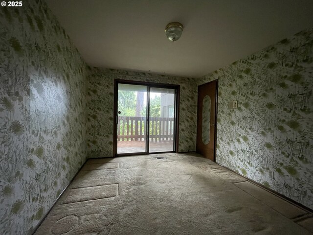 carpeted spare room with wallpapered walls