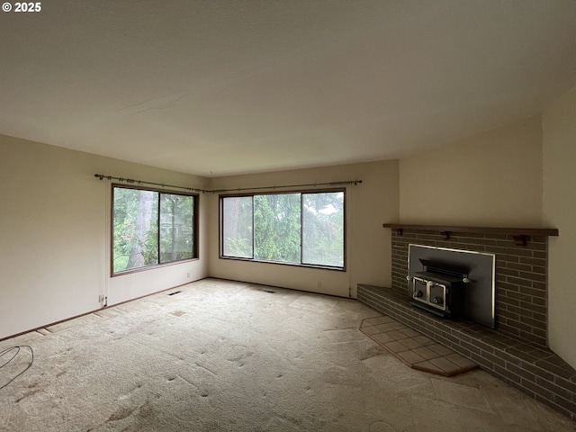 unfurnished living room with carpet floors and a wood stove