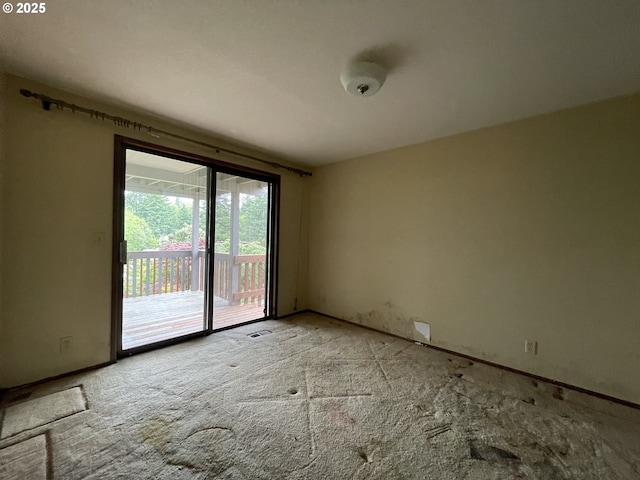 carpeted empty room featuring baseboards