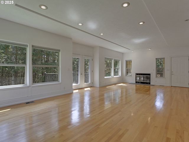 17234 Oakdale Rd, Dallas, OR 97338 - unfurnished living room featuring wood finished floors, a glass covered fireplace, french doors, visible vents, and recessed lighting