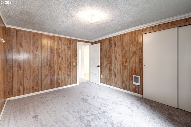 844 SE Cedar St, Hillsboro, OR 97123 - unfurnished bedroom featuring a textured ceiling, a closet, wood walls, carpet, and crown molding