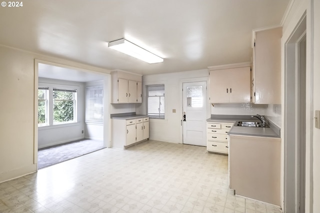 844 SE Cedar St, Hillsboro, OR 97123 - kitchen with light flooring, a sink, baseboards, and white cabinetry