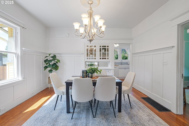 7315 N Smith St, Portland, OR 97203 - dining space featuring a decorative wall, wood finished floors, a chandelier, and a wainscoted wall