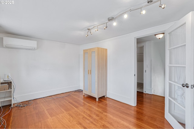 7315 N Smith St, Portland, OR 97203 - below grade area featuring a wall mounted air conditioner, wood finished floors, ornamental molding, and rail lighting