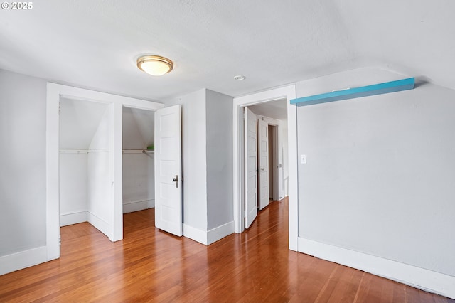 7315 N Smith St, Portland, OR 97203 - unfurnished bedroom featuring a closet, wood finished floors, a walk in closet, and vaulted ceiling