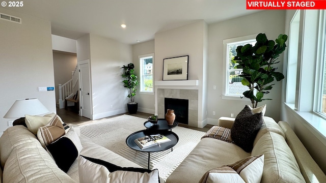 17890 SW Alvord Ln, Beaverton, OR 97007 - living room featuring stairs, healthy amount of natural light, a tiled fireplace, recessed lighting, and wood finished floors