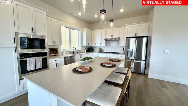 17890 SW Alvord Ln, Beaverton, OR 97007 - kitchen with stainless steel appliances, white cabinets, backsplash, dark wood-type flooring, and a kitchen island