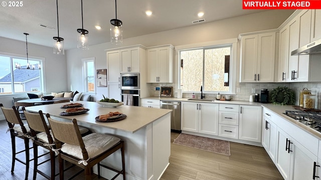 17890 SW Alvord Ln, Beaverton, OR 97007 - kitchen featuring stainless steel appliances, backsplash, white cabinets, and recessed lighting