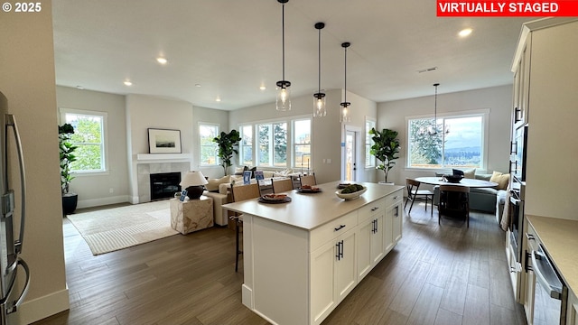 17890 SW Alvord Ln, Beaverton, OR 97007 - kitchen with open floor plan, dark wood-type flooring, a tiled fireplace, recessed lighting, and light countertops