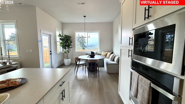 17890 SW Alvord Ln, Beaverton, OR 97007 - kitchen with built in microwave, oven, white cabinets, and pendant lighting